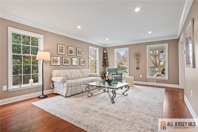 living area featuring crown molding, wood finished floors, baseboards, and recessed lighting