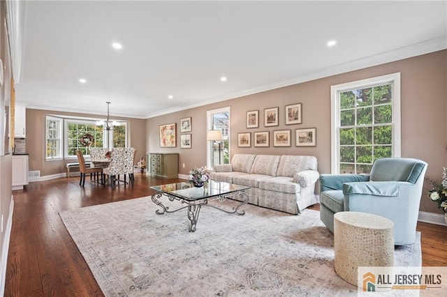 living room with crown molding, baseboards, a chandelier, dark wood-type flooring, and recessed lighting