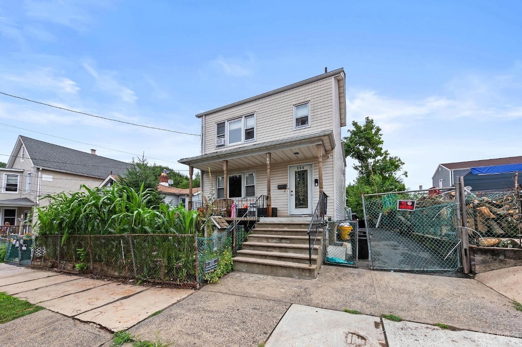 view of front of property with covered porch, a fenced front yard, and a gate