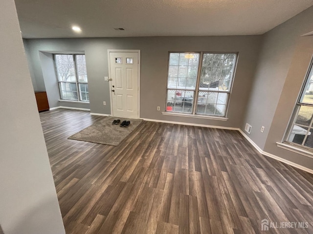 foyer featuring dark hardwood / wood-style floors and a textured ceiling