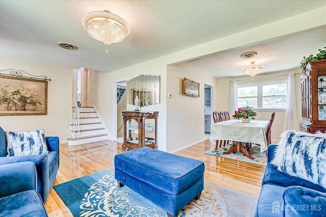 living area with wood finished floors, stairs, and baseboards