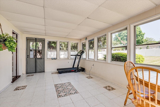 exercise room with plenty of natural light, a drop ceiling, and light tile patterned floors
