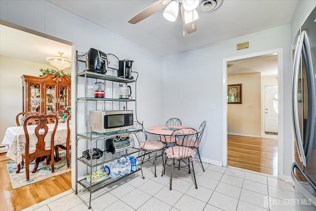 dining room featuring a ceiling fan, light tile patterned flooring, ornamental molding, and baseboards