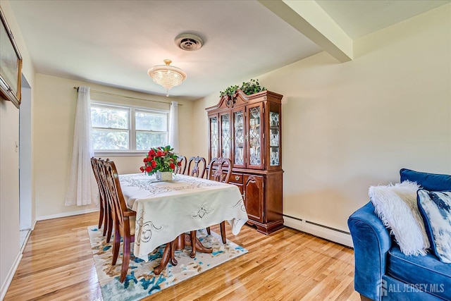 dining room featuring a baseboard heating unit and light wood-style flooring