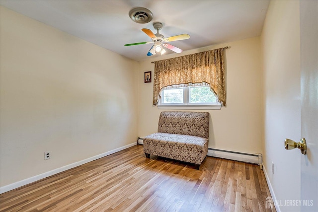 living area with a baseboard radiator, wood-type flooring, ceiling fan, and baseboards