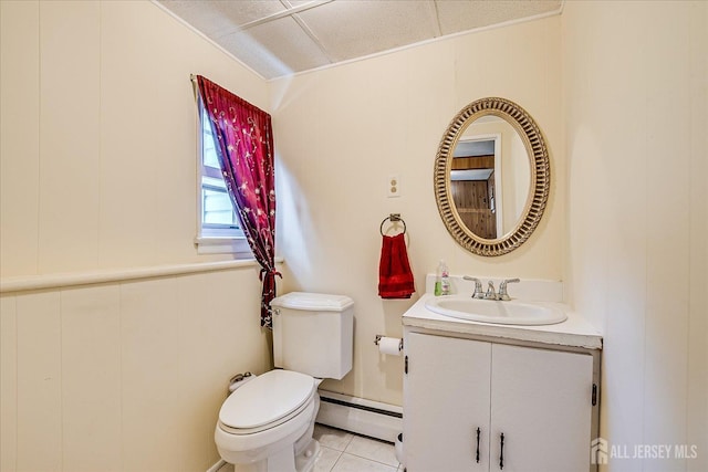 bathroom featuring a baseboard heating unit, toilet, vanity, and tile patterned floors