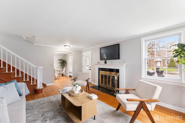 334 Hillcrest Ave, Plainfield, NJ 07062 - living room with arched walkways, ornamental molding, a glass covered fireplace, stairway, and wood finished floors