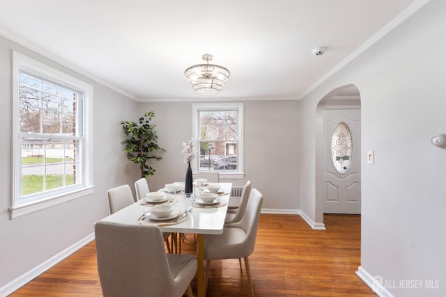 334 Hillcrest Ave, Plainfield, NJ 07062 - dining area featuring healthy amount of natural light, arched walkways, baseboards, wood finished floors, and ornamental molding
