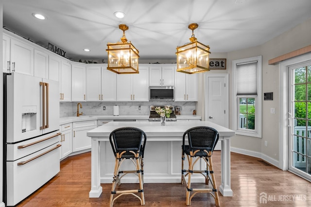 20 Mccormick Ave, Old Bridge, NJ 08857 - kitchen with high end white refrigerator, stainless steel microwave, stove, light countertops, and a chandelier