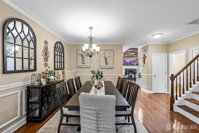 20 Mccormick Ave, Old Bridge, NJ 08857 - dining room featuring a chandelier, crown molding, wood finished floors, a decorative wall, and stairway