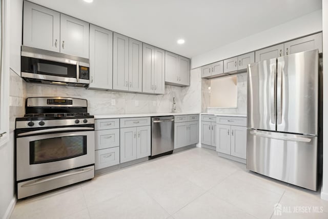 210 N 2nd Ave, Highland Park, NJ 08904 - kitchen with appliances with stainless steel finishes, gray cabinets, light countertops, backsplash, and recessed lighting