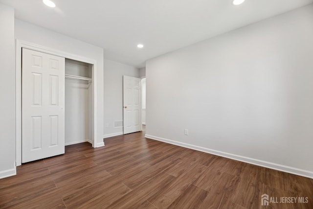 210 N 2nd Ave, Highland Park, NJ 08904 - unfurnished bedroom featuring dark wood-style flooring, baseboards, recessed lighting, and a closet