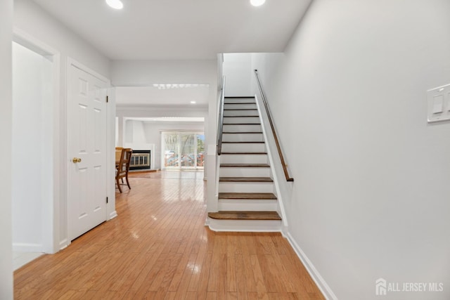 210 N 2nd Ave, Highland Park, NJ 08904 - staircase featuring recessed lighting, hardwood / wood-style flooring, baseboards, and a glass covered fireplace