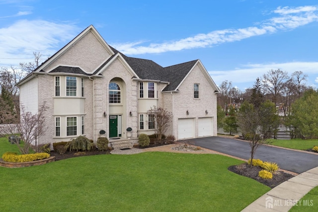 view of front of home with aphalt driveway, a front yard, brick siding, and an attached garage