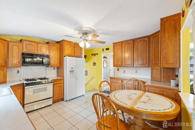 kitchen featuring white appliances, light countertops, a ceiling fan, and brown cabinets