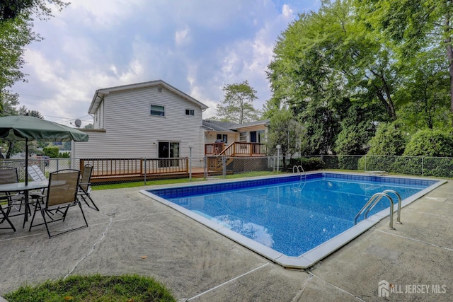 view of swimming pool with a deck, a patio area, outdoor dining area, and fence