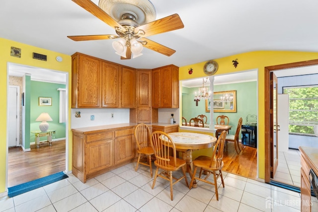 dining room with light tile patterned floors, a chandelier, and a ceiling fan