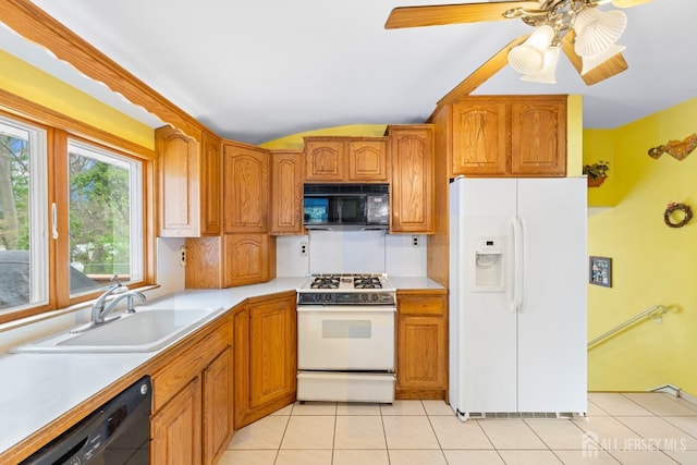 kitchen featuring black appliances, a sink, light countertops, brown cabinetry, and vaulted ceiling