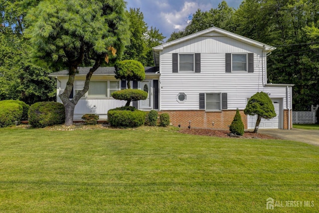 split level home featuring a front lawn, brick siding, and driveway