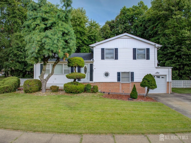 tri-level home featuring asphalt driveway, brick siding, and an attached garage