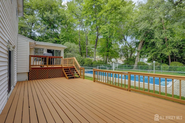 deck with a fenced backyard and view of wooded area