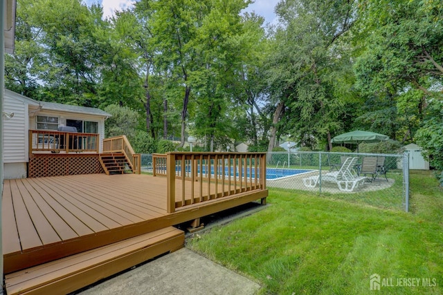 wooden terrace with view of wooded area and a patio
