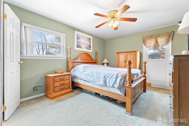 bedroom with light colored carpet, a ceiling fan, and baseboards
