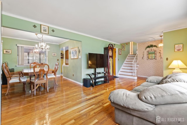 living room with light wood-style floors, crown molding, stairs, a chandelier, and baseboards