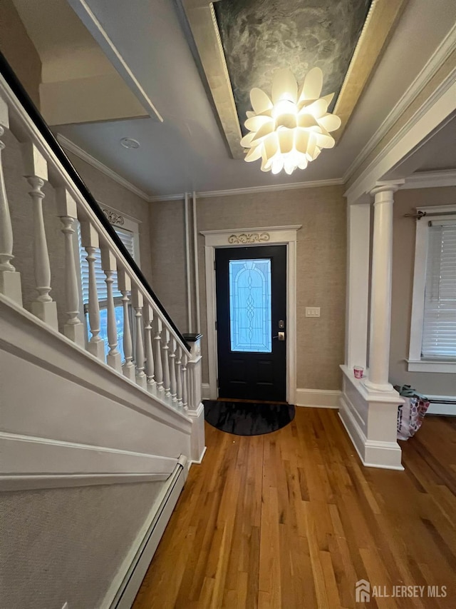 foyer with hardwood / wood-style floors and crown molding