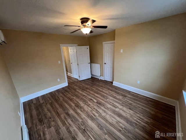 unfurnished bedroom with ceiling fan, dark wood-type flooring, and a textured ceiling