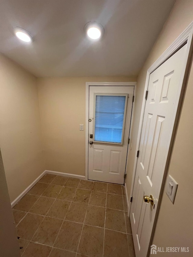 doorway with dark tile patterned flooring