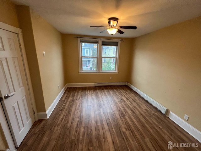 unfurnished room with ceiling fan, dark wood-type flooring, and a baseboard radiator