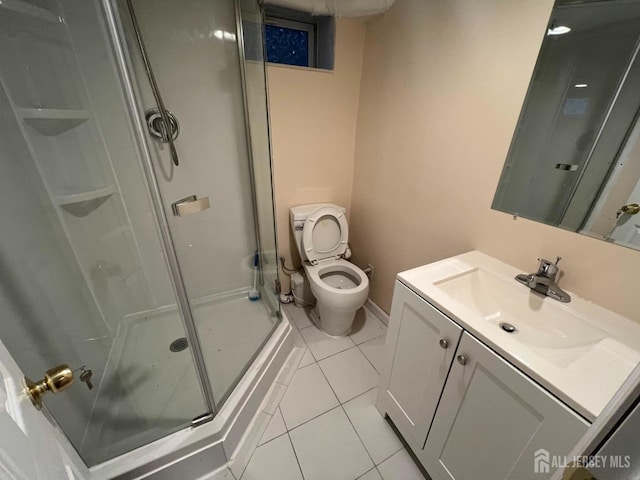 bathroom with tile patterned floors, a shower with door, vanity, and toilet