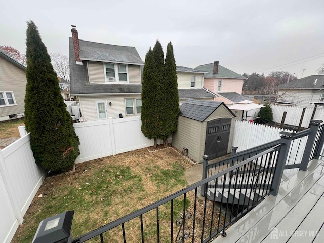 exterior space with a yard, a deck, and a storage unit