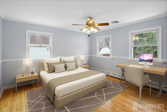 bedroom with a baseboard radiator, visible vents, crown molding, and wood finished floors