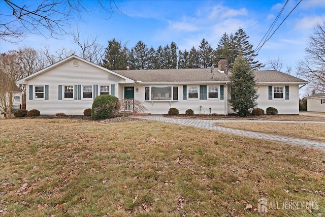 single story home with a chimney and a front lawn