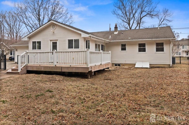 rear view of house featuring a chimney and a wooden deck