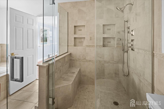 full bathroom with a stall shower and tile patterned flooring