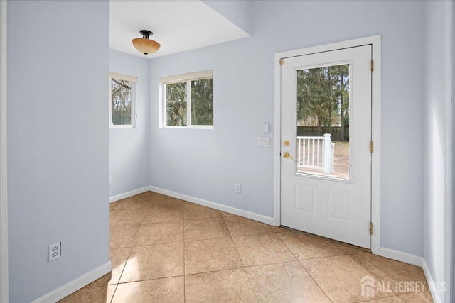 doorway featuring baseboards and light tile patterned floors