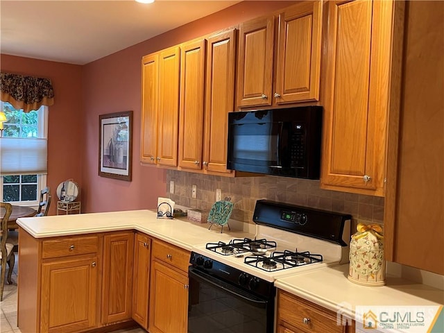 1 Silcox Pl, Franklin, NJ 08873 - kitchen featuring gas range, black microwave, a peninsula, backsplash, and brown cabinetry