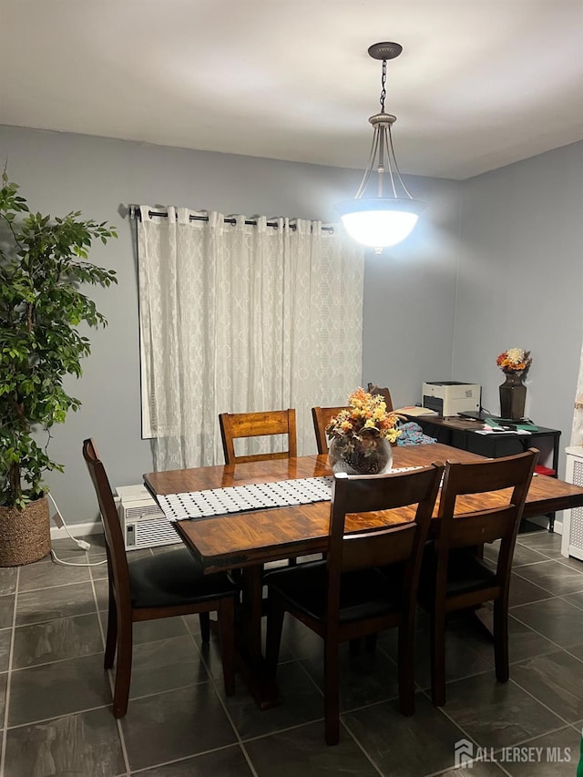 dining area with dark tile patterned flooring and baseboards