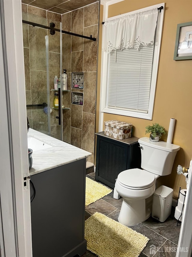 bathroom featuring tiled shower, radiator heating unit, vanity, and toilet