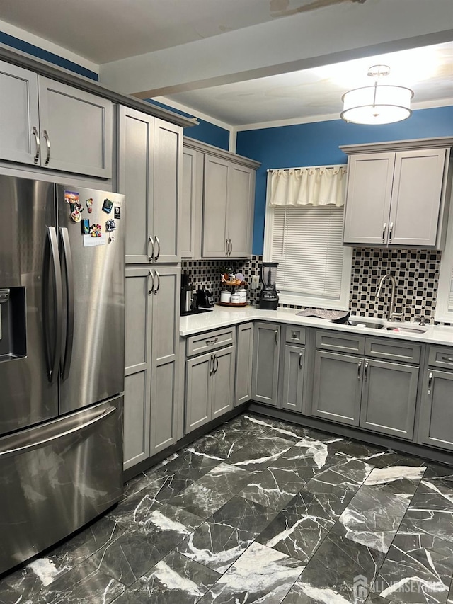 kitchen featuring backsplash, ornamental molding, sink, stainless steel fridge with ice dispenser, and gray cabinets