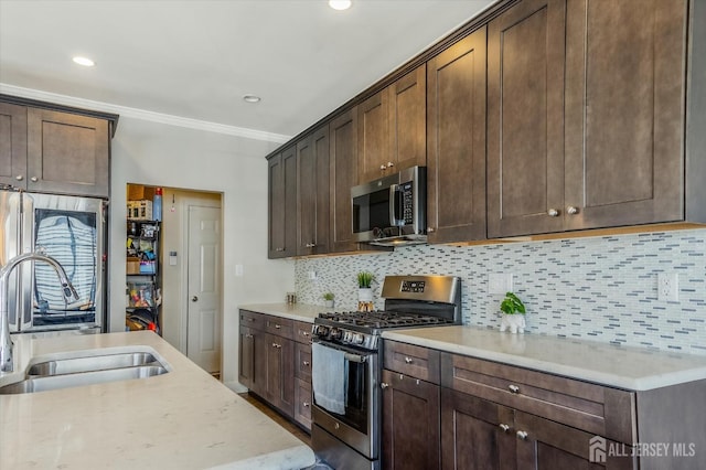 58 Begonia Ln, Monroe, NJ 08831 - kitchen featuring stainless steel appliances, a sink, crown molding, dark brown cabinets, and backsplash