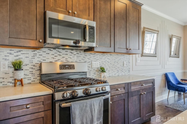 58 Begonia Ln, Monroe, NJ 08831 - kitchen with appliances with stainless steel finishes, ornamental molding, light countertops, decorative backsplash, and dark wood-type flooring