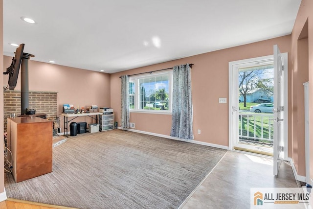 office space featuring baseboards, a wood stove, and recessed lighting
