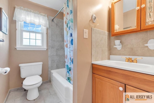 bathroom with baseboards, tile patterned floors, vanity, toilet, and shower / bath combo with shower curtain