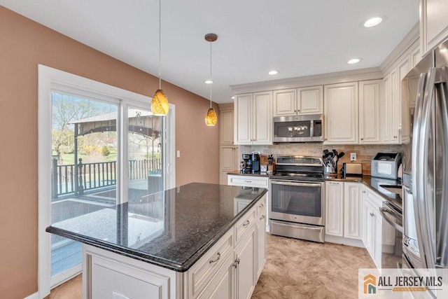 kitchen with hanging light fixtures, dark stone countertops, stainless steel appliances, backsplash, and a kitchen island