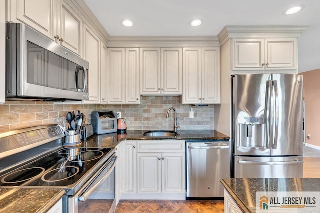 kitchen with stainless steel appliances, decorative backsplash, a sink, and dark stone countertops
