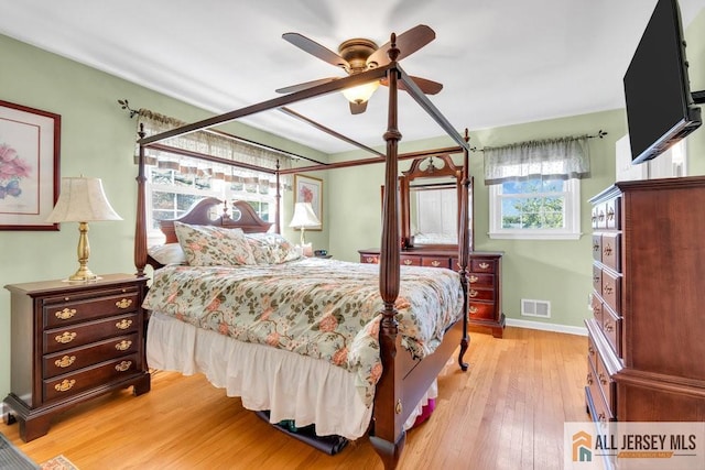 bedroom featuring baseboards, visible vents, ceiling fan, and light wood-style floors